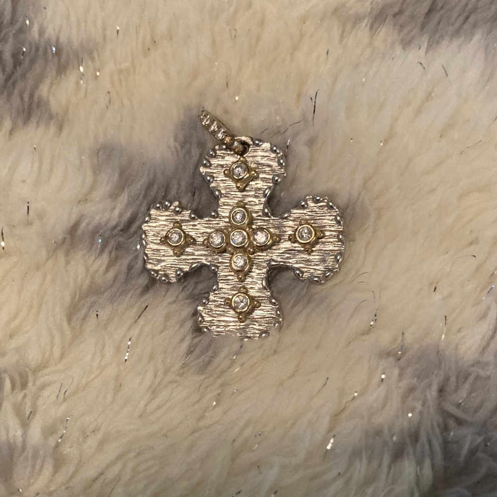 Elegant sterling silver and gold textured cross pendant with sparkling accents.